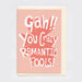 An A6 greeting card with a light pink front and cream envelope, featuring the phrase 'Gah!! You Crazy ROMANTIC FOOLS!' in large white retro lettering over a red burst graphic, shown on a light grey background.
