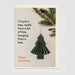 A Christmas greeting card sitting on a cream envelope, featuring a green hanging tree ornament, pine branches at the top right, and the text, 'I'm just a tree, made from a bit of tree, hanging from a tree. Happy Christmas.