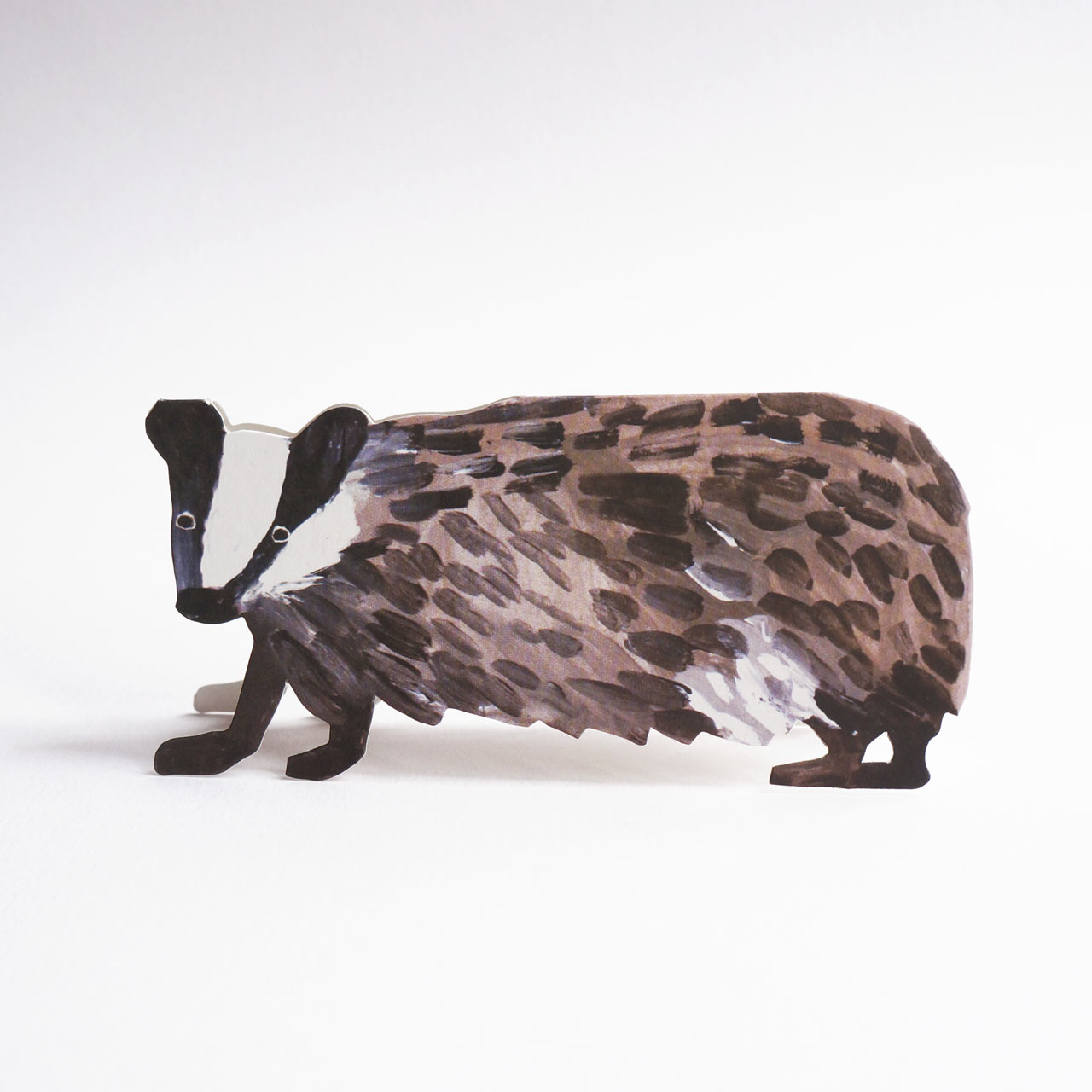 A die-cut badger greeting card with hand-painted details, shown against a plain white background.