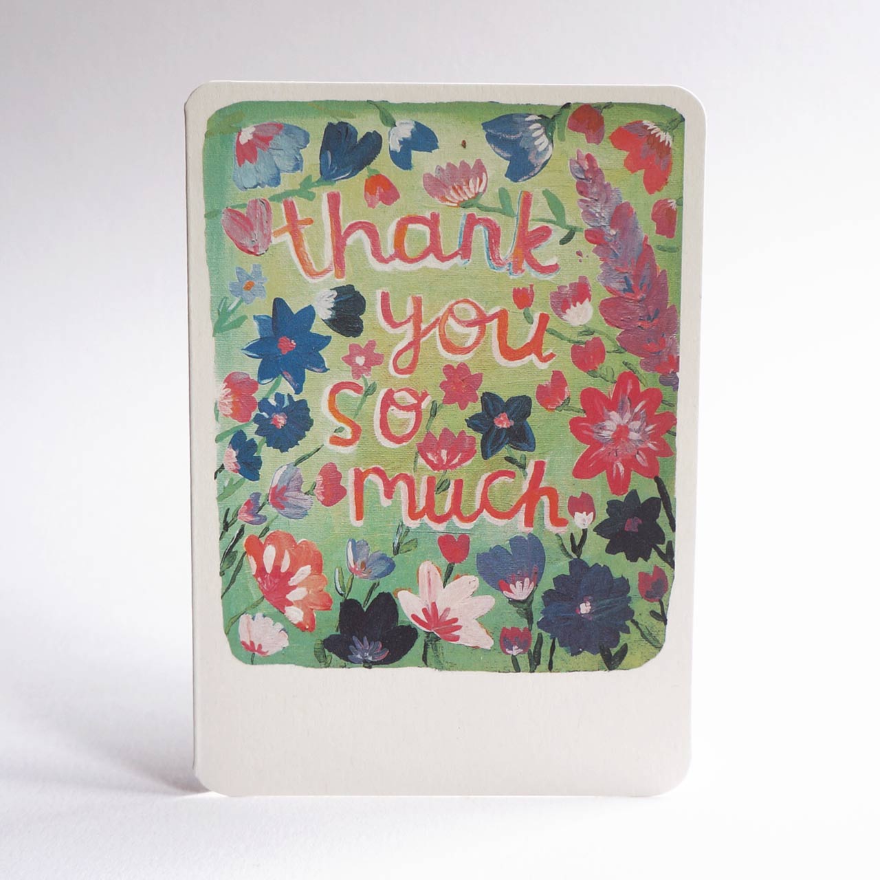 An A6 greeting card with rounded corners, featuring a colourful impressionistic floral watercolour painting and the words 'thank you so much' in pink cursive lettering on a light green background.