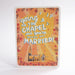 An A6 greeting card with rounded corners, featuring the phrase “going to the CHAPEL and you’re gonna get MARRIED!” in large blue and white lettering over a warm orange and yellow sunburst background, decorated with floral motifs and a small church illustration. The item is photographed alone on a clean white background.