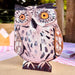 A die-cut Little Owl card with large orange eyes and brown wings, standing on a table.
