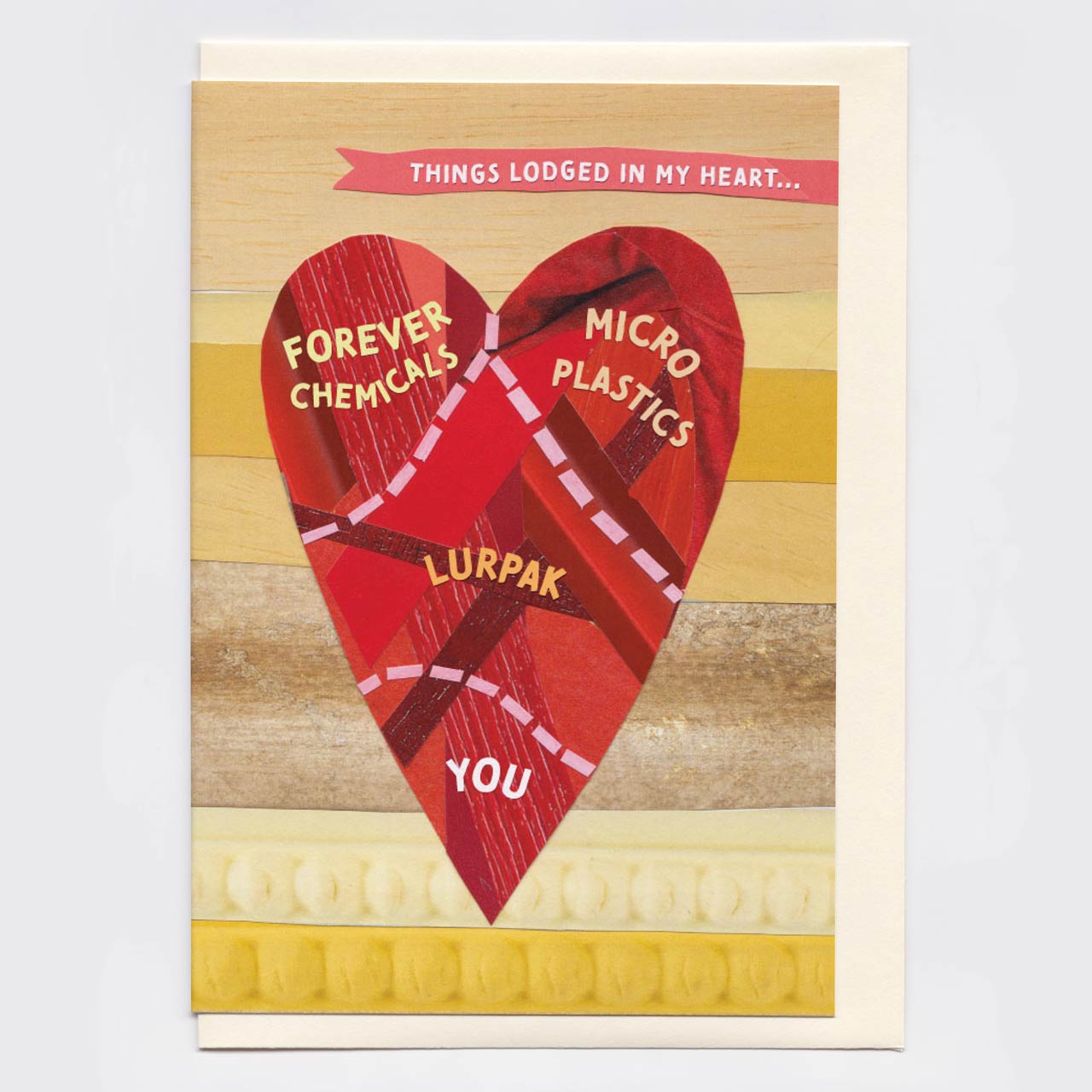 A greeting card featuring a large red heart made of layered materials with text labels including 'FOREVER CHEMICALS', 'MICRO PLASTICS', 'LURPAK', and 'YOU'. The top banner reads 'THINGS LODGED IN MY HEART.