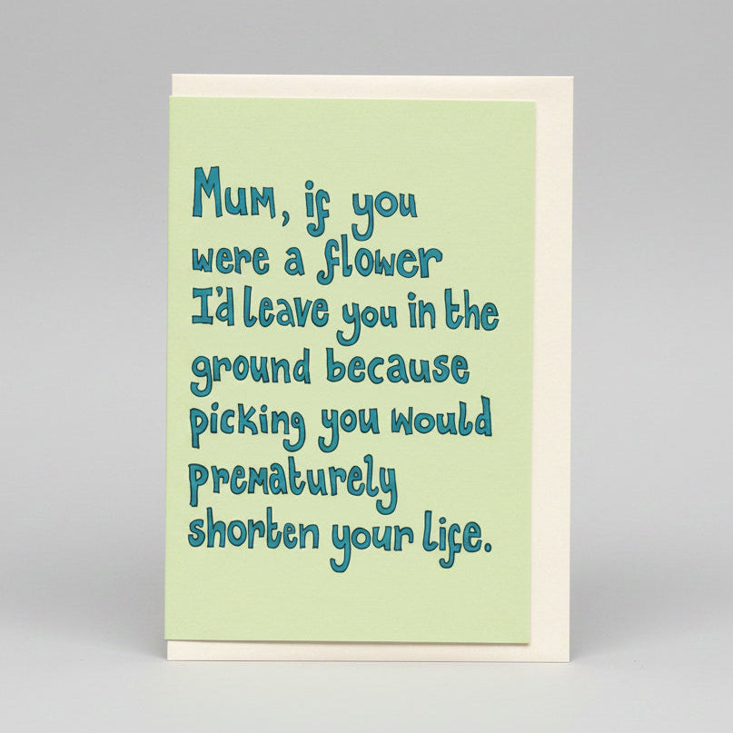 An A6 greeting card with a light green front and a white envelope behind it, photographed on a neutral grey studio background. The card reads, 'Mum, if you were a flower I'd leave you in the ground because picking you would prematurely shorten your life.