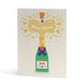 An A6 greeting card featuring a whimsical illustration of a green champagne bottle with a purple ribbon, popping open to release a gold burst of champagne and the words 'Woo Hoo!' on a white background.