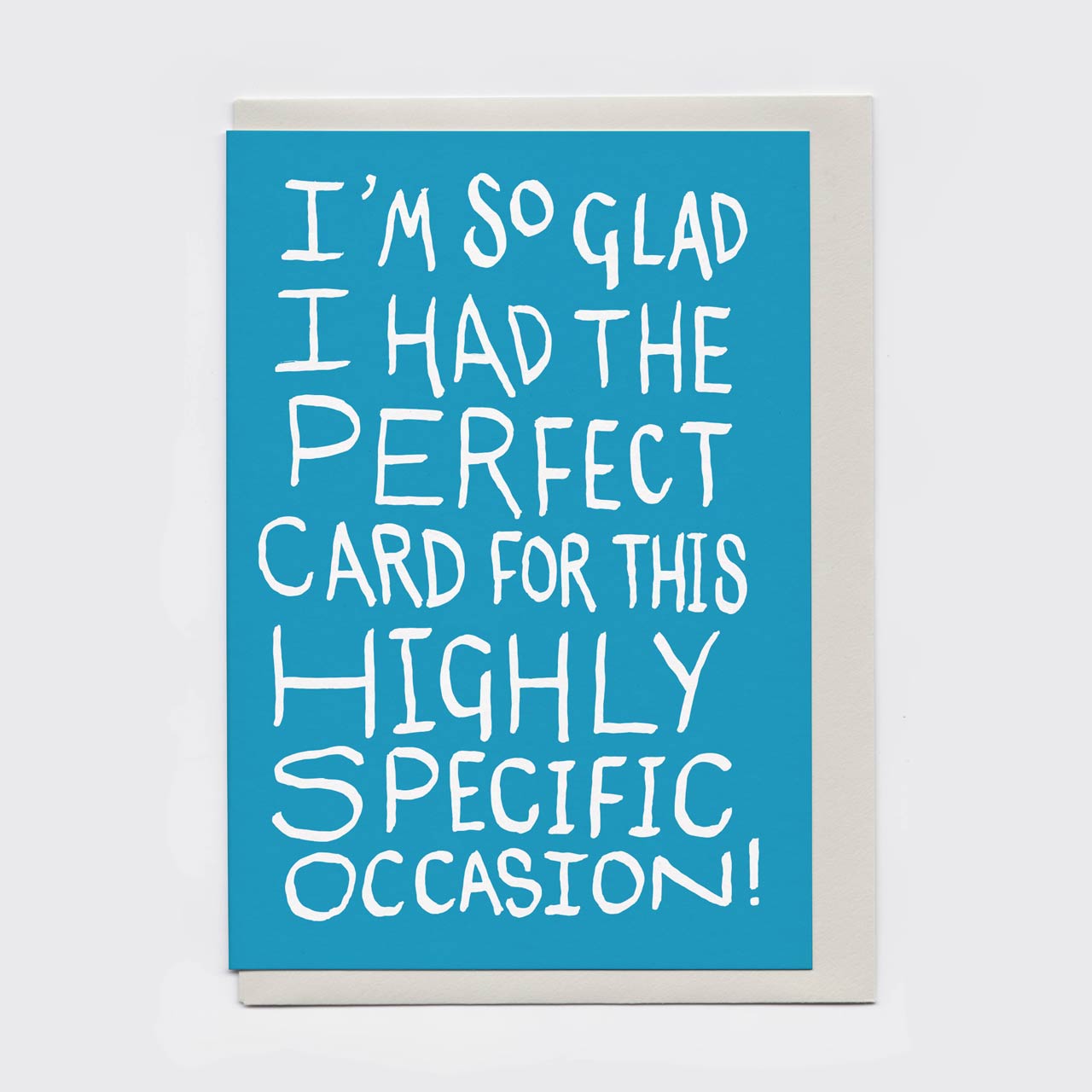 Funny all-purpose A6 greeting card with white hand-lettered text saying: 'I'M SO GLAD I HAD THE PERFECT CARD FOR THIS HIGHLY SPECIFIC OCCASION!' It is show here, in flatlay, with a matching grey envelope.