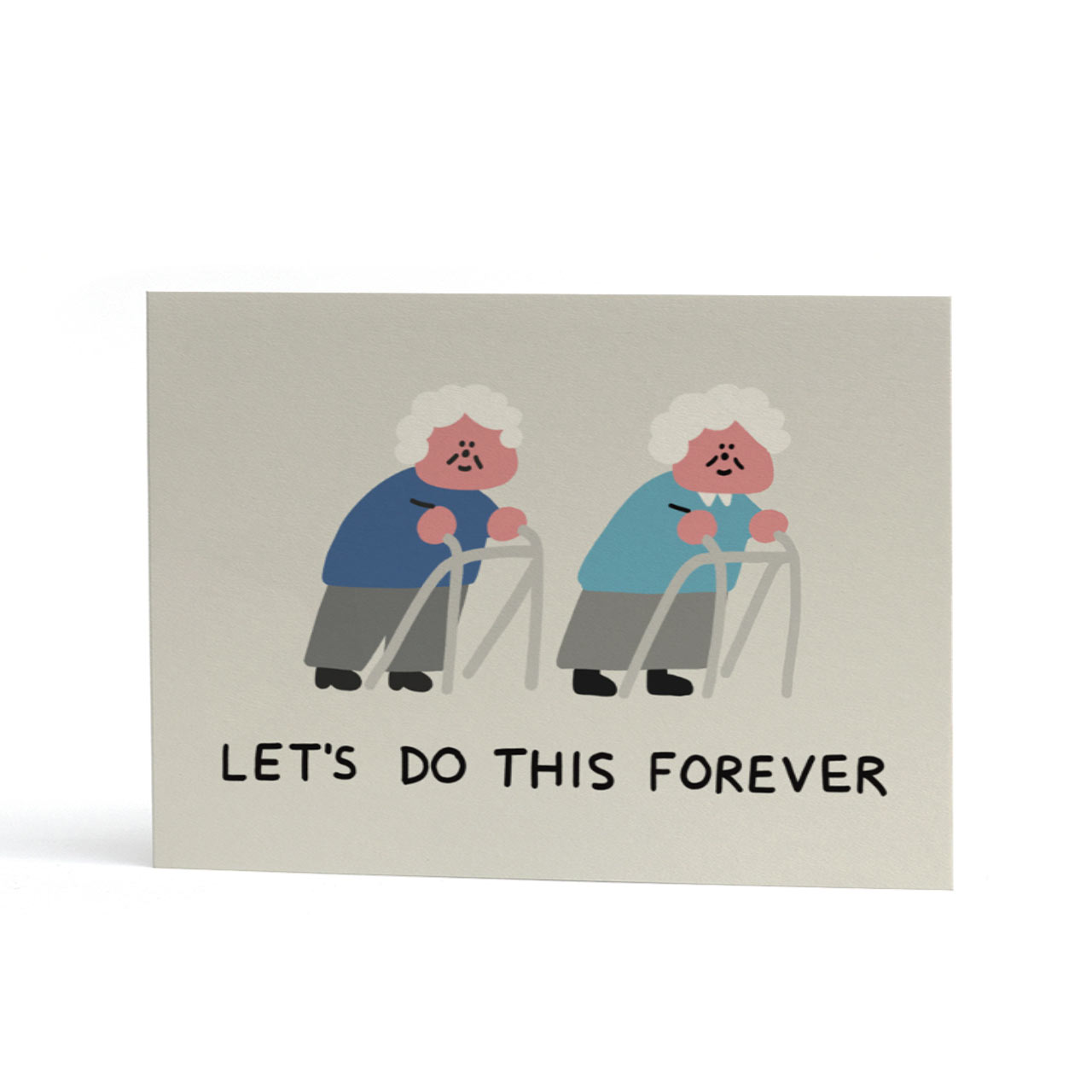 An A6 greeting card with a light grey background featuring an illustration of two smiling elderly figures using walkers, with the text 'LET'S DO THIS FOREVER' printed below.