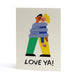 A greeting card featuring a minimalist illustration of a couple embracing, with the text 'LOVE YA!' printed below in black. The card has a white background and is photographed standing upright against a white studio backdrop.